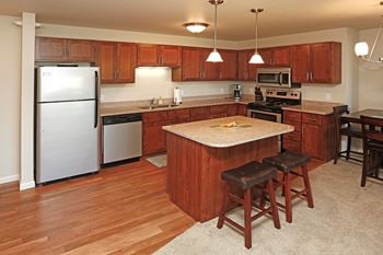 Spacious kitchen with stainless steel appliances, pendant lighting, and a kitchen island.